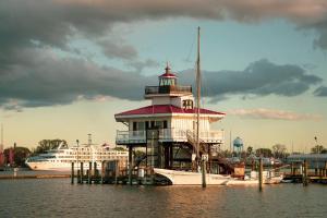 a lighthouse in the water next to a cruise ship at Pint-Sized on Poplar in Cambridge