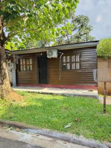 a wooden house with a door and a tree at Hogape in Posadas