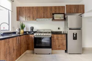a kitchen with stainless steel appliances and wooden cabinets at Casa Brianzzas in Miranda