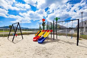a playground with a row of slides in the sand at Casa Brianzzas in Miranda