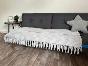 a bedroom with a bed with a black headboard and a table at Zimmer, Apartment A3 in Offenberg