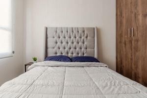 a bedroom with a large white bed with blue pillows at Casa Brianzzas in Miranda