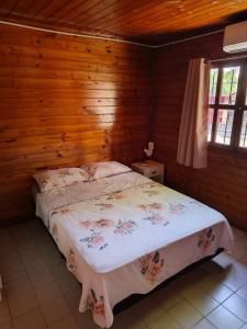 a bedroom with a bed with a wooden wall at Hogape in Posadas