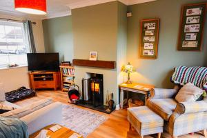 a living room with a fireplace and a tv at Chapel Bricks in Withernwick
