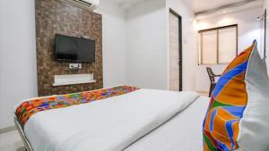 a bedroom with a bed and a tv on a brick wall at Hotel Krishna Inn in Bhiwandi