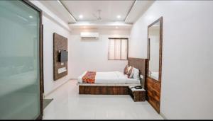 a bedroom with a bed and a mirror at Hotel Krishna Inn in Bhiwandi