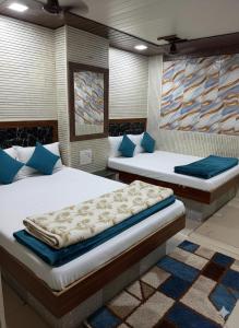 two beds in a room with blue pillows at Hotel Al Mehraj in Mumbai