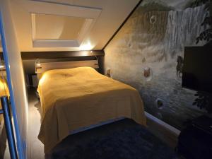 a bedroom with a bed with a yellow blanket on it at Studio Amnesia in Heerhugowaard