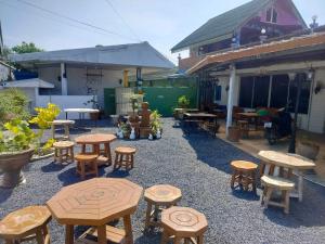 a group of wooden tables and stools in a yard at Khao Ban Eings in Sena