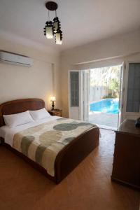 a bedroom with a bed and a sliding glass door at Paradise Villa - King Mariout in King Mariout +27 photos
