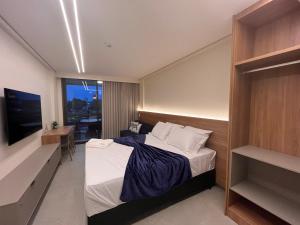 una camera d'albergo con un letto e una televisione di Sole e Mare Flat a Ipojuca