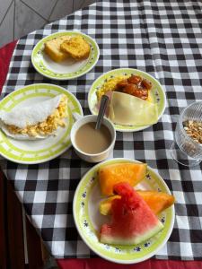 a table with plates of food on a checkered table cloth at Pousada Casa Bali in Fortaleza