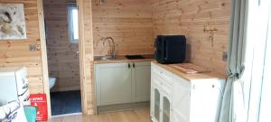 a kitchen in a log cabin with a tv on a counter at Foxwell in Ballina