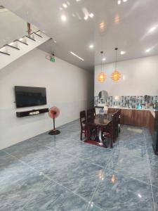 a living room with a table and a tv at Cherry House villa in Hà Tiên