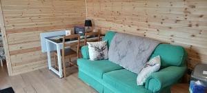 a green couch sitting in a room with a table at Foxwell in Ballina