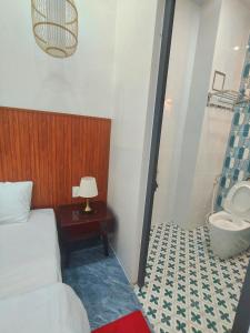 a bedroom with a bed and a bathroom with a sink at Cherry House villa in Hà Tiên +24 photos