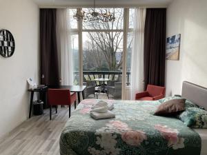 a bedroom with a bed and a table and a window at Hotel Plato by Hofstad Studios in Scheveningen