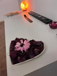 a bowl of purple flowers on a white table at B&B Villa Friedmann Nonantola Modena in Nonantola