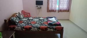 a bedroom with a couch with a blanket on it at Vibheeshan Villa in Yelagiri