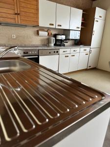 a kitchen with white cabinets and a stainless steel counter top at Zimmer, Apartment A3 in Offenberg +10 photos