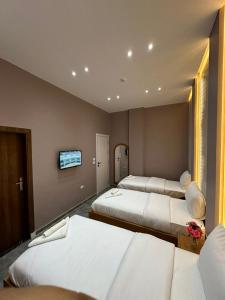 castello hotel في القاهرة: غرفة فندق بها ثلاثة أسرّة وتلفزيون بشاشة مسطحة +45 صورة