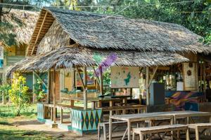 a restaurant with tables and a thatched roof at Bunga Jabe in Karimunjawa