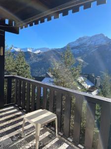 a white bench on a balcony with a mountain view at T2 Praloup 1500 in Uvernet