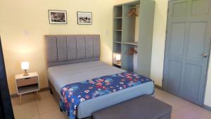 a small bedroom with a bed and a small table at Villas Pura Vida - Guapinol in Río Negro