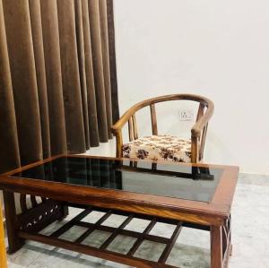 a coffee table with a chair and a glass top at Lallan Top Hotel in Unnāo
