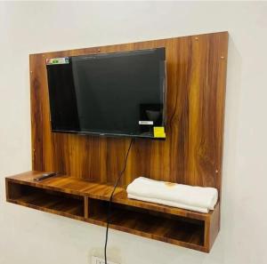 a flat screen tv on a wooden wall at Lallan Top Hotel in Unnāo