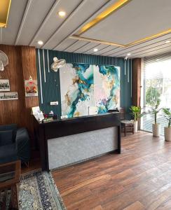 a reception desk in a lobby with a large painting at Lallan Top Hotel in Unnāo