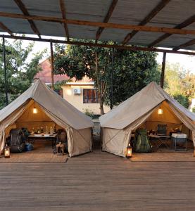 two large tents sitting on a wooden deck at karibu la kossa in Tuvaila