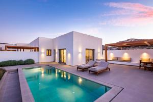 a villa with a swimming pool and a patio at Manos Villas in Karpathos