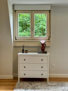 a dresser in a room with a window at Boutique Apartment Villa Jaenisch in Kaiserslautern +21 photos