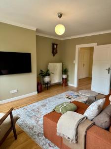 a living room with a couch and a flat screen tv at Boutique Apartment Villa Jaenisch in Kaiserslautern