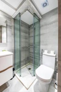 a bathroom with a toilet and a glass shower at La Perle Rare in Tangier