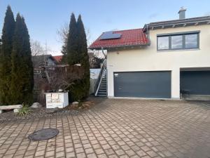 a house with two garage doors and a driveway at Bordinghouse Arndt in Memmingen