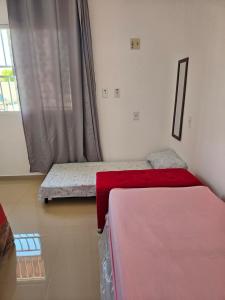 two beds in a room with a window at Cantinho das Joaninhas in Prado