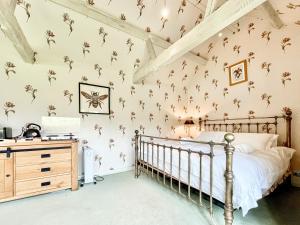 a bedroom with a bed and flowers on the wall at Cottage 3 - Uk46609 in Broughton