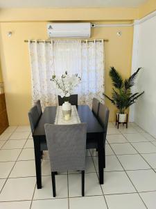 a dining room with a black table and chairs at Lyn Tropical Getaway in Port-of-Spain