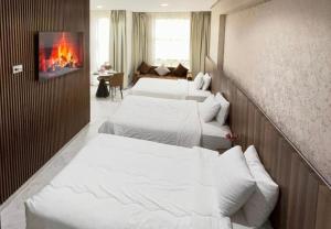 three beds in a room with a fire in the wall at La Perle Rare in Tangier