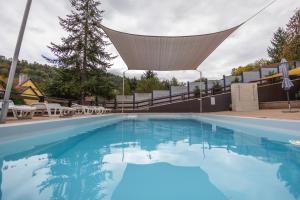 a large swimming pool with a net over the top at Forrás Panzió és Apartman in Orfű +19 photos