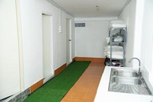 a kitchen with a sink and a green floor at Sengao backpacker in Vang Vieng