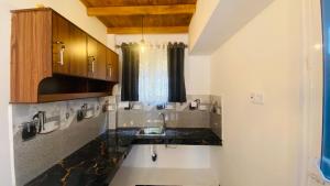 a kitchen with a sink and wooden cabinets at Coco Wave Midigama in Midigama East
