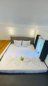 a white bed with two bows on it at Coco Wave Midigama in Midigama East +11 photos