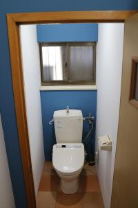 a bathroom with a white toilet and a window at Kamoshika Cottage Hakuba in Hakuba
