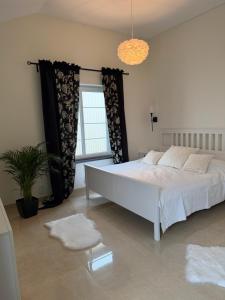 a bedroom with a white bed and a window at Eden-Dom Wakacyjny z Domkiem Gościnnym in Trelleborg