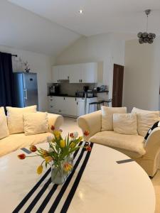 a living room with two couches and a table with flowers at Eden-Dom Wakacyjny z Domkiem Gościnnym in Trelleborg