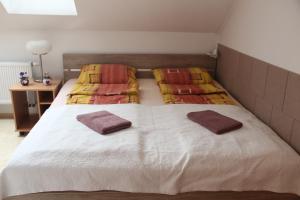 a bedroom with a bed with two pillows on it at Apartment Lilianna in Karlovy Vary