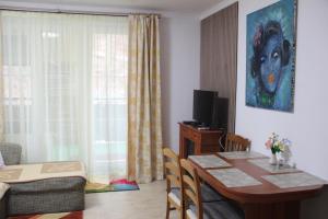 a living room with a dining room table and a bedroom at Apartment Lilianna in Karlovy Vary